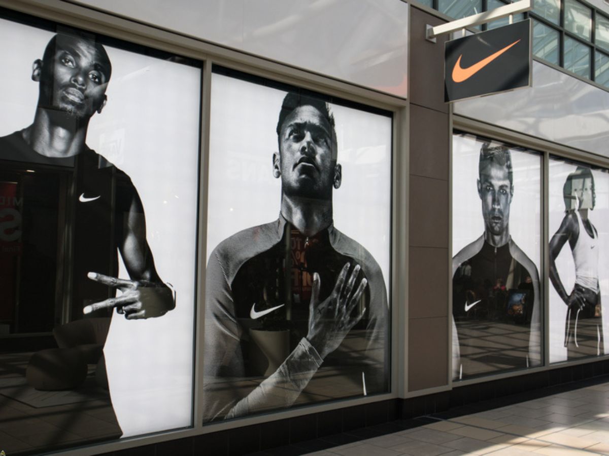 Exterior of Nike store shop showing company logo, sign, signage and branding and window display